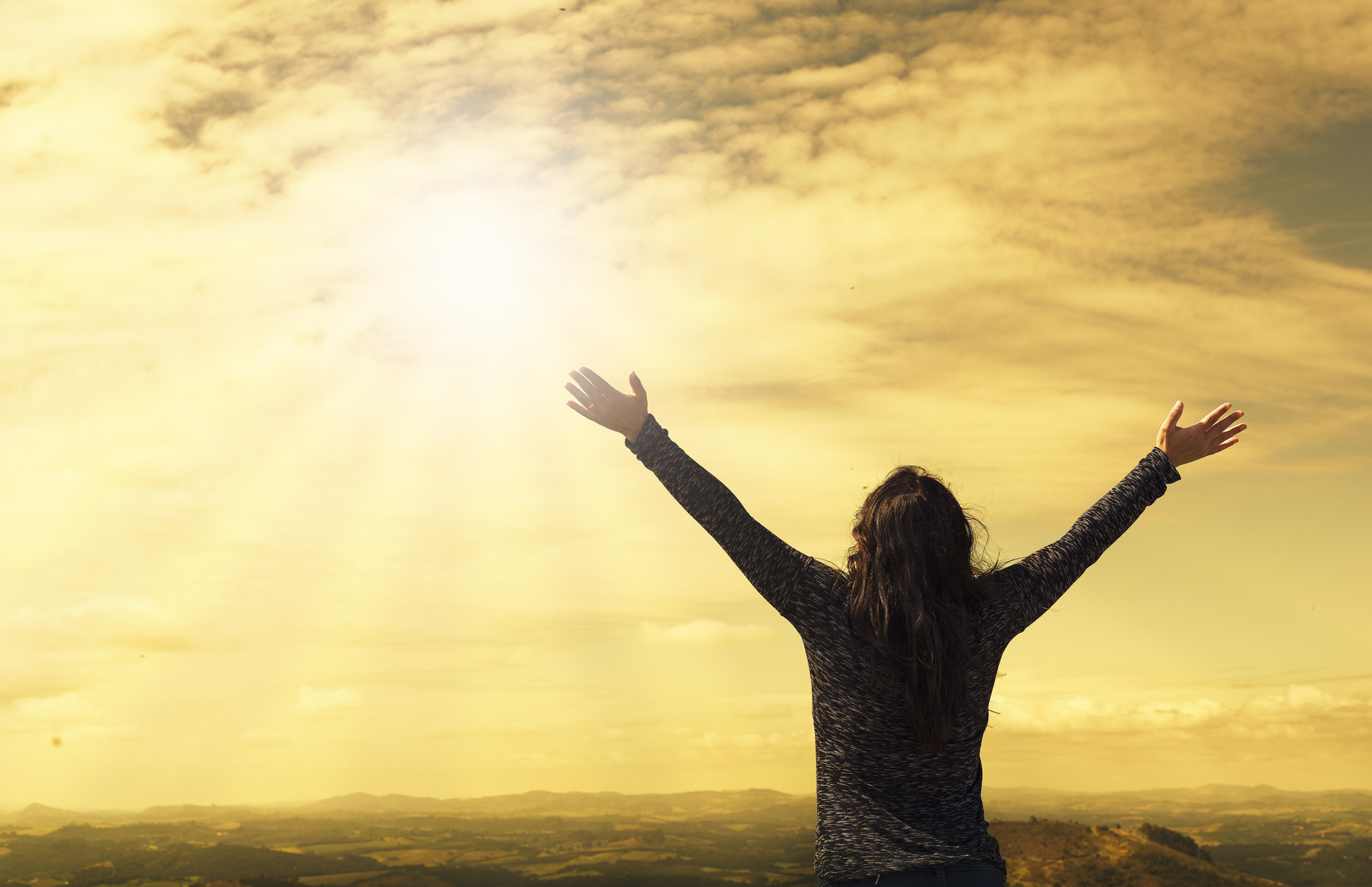 Woman with Open Arms Looking at the Sun